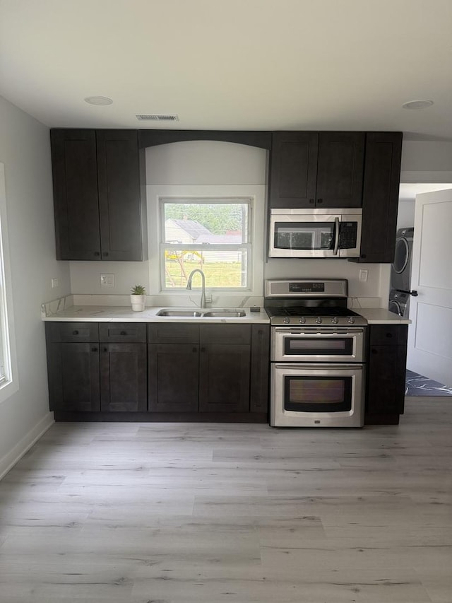 309 SE Circle Dr, Joliet, IL 60433 - kitchen with stainless steel appliances, light wood-type flooring, and washer / clothes dryer
