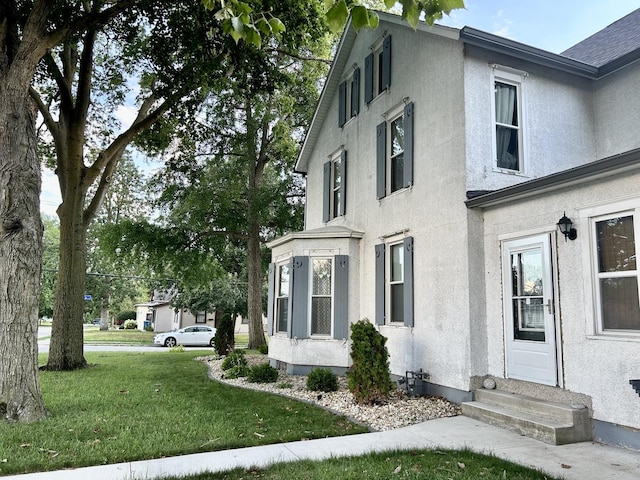 2603 3rd St, Peru, IL 61354 - view of property exterior with entry steps, a lawn, and stucco siding