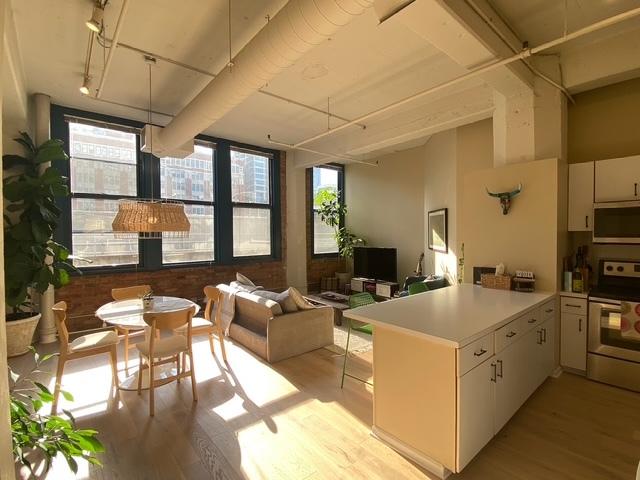 124 W Polk St Unit 203, Chicago, IL 60605 - kitchen featuring appliances with stainless steel finishes, a peninsula, light wood-style floors, white cabinets, and light countertops