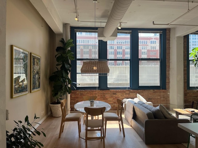 124 W Polk St Unit 203, Chicago, IL 60605 - dining area featuring rail lighting, wood finished floors, and brick wall