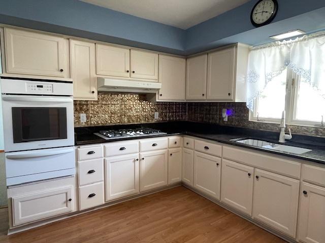 512 Tana Ln, Joliet, IL 60435 - kitchen with white oven, a warming drawer, gas stovetop, under cabinet range hood, and dark countertops