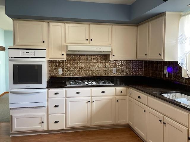 512 Tana Ln, Joliet, IL 60435 - kitchen with oven, a warming drawer, gas cooktop, under cabinet range hood, and dark countertops