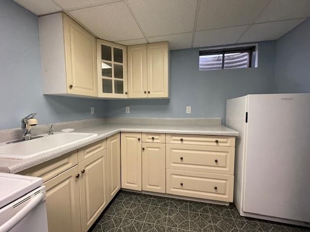 512 Tana Ln, Joliet, IL 60435 - kitchen with freestanding refrigerator, a paneled ceiling, stove, light countertops, and glass insert cabinets