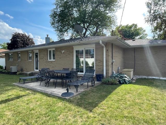 512 Tana Ln, Joliet, IL 60435 - back of house with brick siding, a lawn, a patio area, and a chimney