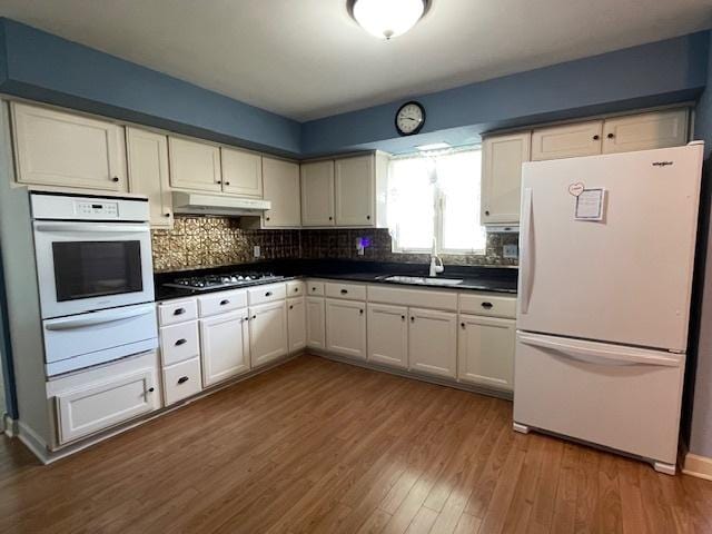 512 Tana Ln, Joliet, IL 60435 - kitchen featuring white appliances, a warming drawer, under cabinet range hood, dark countertops, and dark wood-style floors