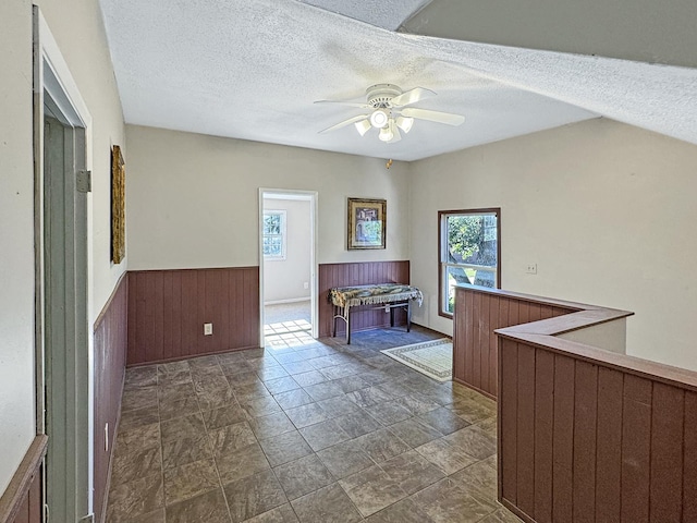 725 Opal St, Marseilles, IL 61341 - interior space featuring wainscoting, a textured ceiling, ceiling fan, wood walls, and dark stone finish flooring