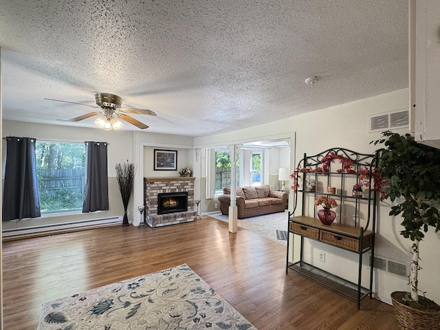 725 Opal St, Marseilles, IL 61341 - living room with baseboard heating, healthy amount of natural light, a textured ceiling, ceiling fan, and wood finished floors