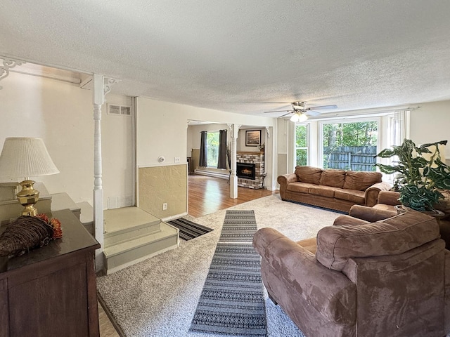 725 Opal St, Marseilles, IL 61341 - living room featuring a textured ceiling, a ceiling fan, a warm lit fireplace, and carpet