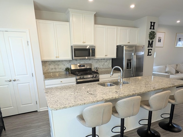 63 Nicholas Dr W, Des Plaines, IL 60016 - kitchen with stainless steel appliances, an island with sink, backsplash, white cabinets, and recessed lighting