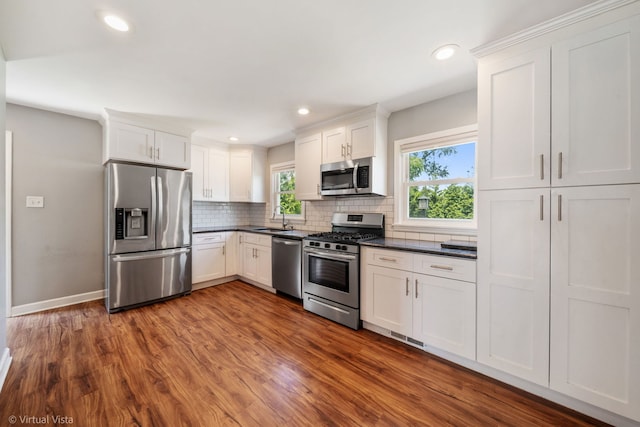 15 Ridge Rd, Lemont, IL 60439 - kitchen with appliances with stainless steel finishes, dark countertops, backsplash, dark wood-style floors, and white cabinetry