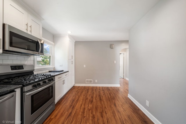 15 Ridge Rd, Lemont, IL 60439 - kitchen with stainless steel appliances, dark countertops, arched walkways, dark wood-style flooring, and recessed lighting