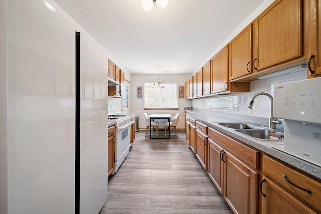 941 N Swift Rd Unit 201, Addison, IL 60101 - kitchen featuring white gas range, brown cabinets, light wood-type flooring, under cabinet range hood, and backsplash