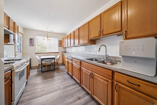 941 N Swift Rd Unit 201, Addison, IL 60101 - kitchen with white range with gas cooktop, brown cabinetry, light wood-type flooring, a chandelier, and decorative backsplash