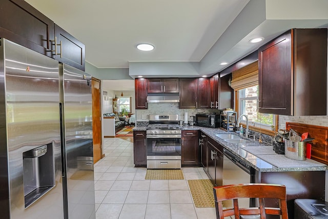 1008 S Beechwood Dr, Mount Prospect, IL 60056 - kitchen featuring appliances with stainless steel finishes, under cabinet range hood, backsplash, light tile patterned floors, and recessed lighting