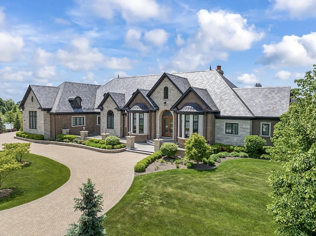 23 Enclave Ct, South Barrington, IL 60010 - view of front facade with stone siding, a high end roof, curved driveway, a front lawn, and a chimney