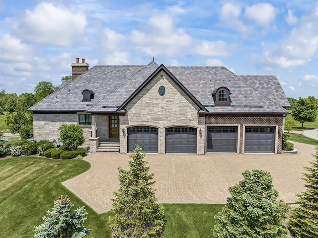 23 Enclave Ct, South Barrington, IL 60010 - french country home with a high end roof, a chimney, decorative driveway, and stone siding