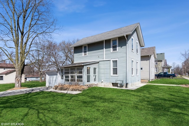 555 S Lasalle St, Aurora, IL 60505 - rear view of house featuring a garage, a sunroom, a lawn, and roof with shingles