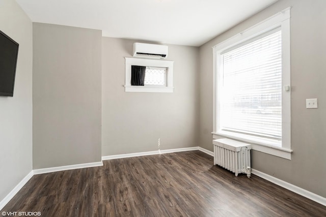 555 S Lasalle St, Aurora, IL 60505 - unfurnished room with a wall mounted AC, radiator, and dark wood finished floors
