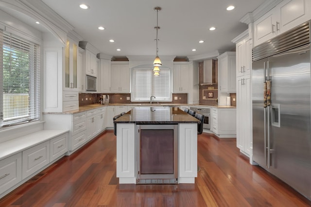 8453 W Bruce Dr, Niles, IL 60714 - kitchen with built in appliances, wall chimney range hood, beverage cooler, white cabinets, and recessed lighting