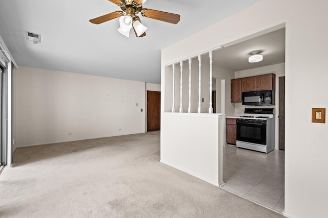 543 Williamsburg Ct Unit C2, Wheeling, IL 60090 - kitchen with white range with gas cooktop, black microwave, light carpet, ceiling fan, and light countertops