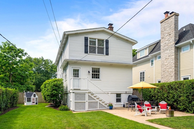 1718 Lake Ave, Wilmette, IL 60091 - rear view of property featuring a storage shed, a patio, and a chimney