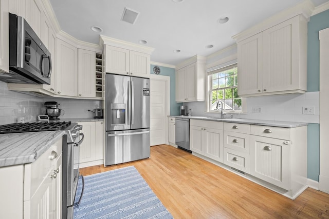1718 Lake Ave, Wilmette, IL 60091 - kitchen featuring appliances with stainless steel finishes, ornamental molding, backsplash, light wood-type flooring, and light stone countertops
