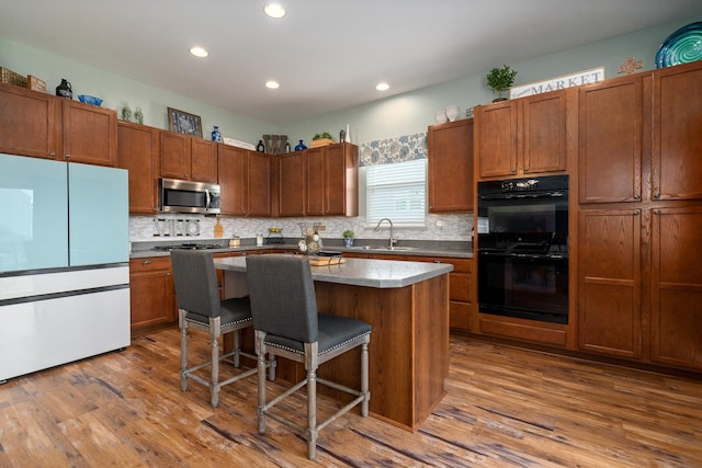 8102 Expedition St, Joliet, IL 60431 - kitchen featuring stainless steel appliances, a kitchen breakfast bar, a center island, decorative backsplash, and recessed lighting