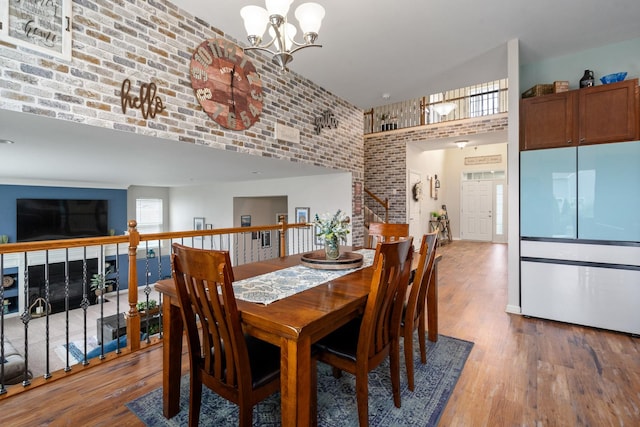8102 Expedition St, Joliet, IL 60431 - dining area featuring a towering ceiling, a chandelier, wood finished floors, and brick wall