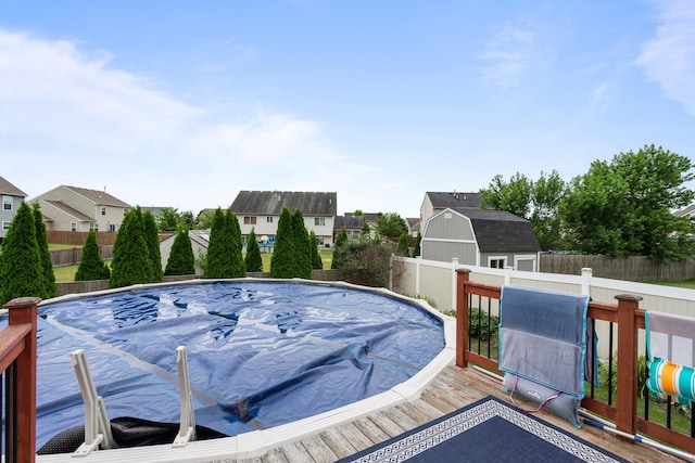 8102 Expedition St, Joliet, IL 60431 - view of pool featuring a fenced backyard, a residential view, a wooden deck, and a shed