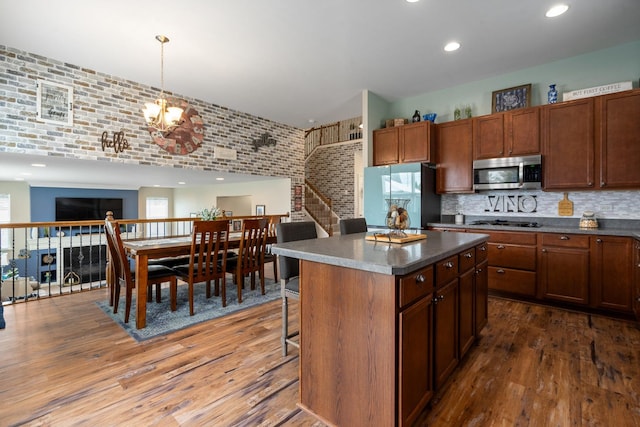 8102 Expedition St, Joliet, IL 60431 - kitchen with stainless steel microwave, freestanding refrigerator, dark wood-style flooring, a kitchen island, and recessed lighting