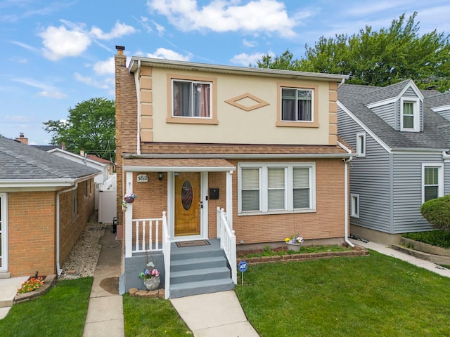 3812 N Pioneer Ave, Chicago, IL 60634 - view of front facade with a front lawn, a chimney, stucco siding, and brick siding