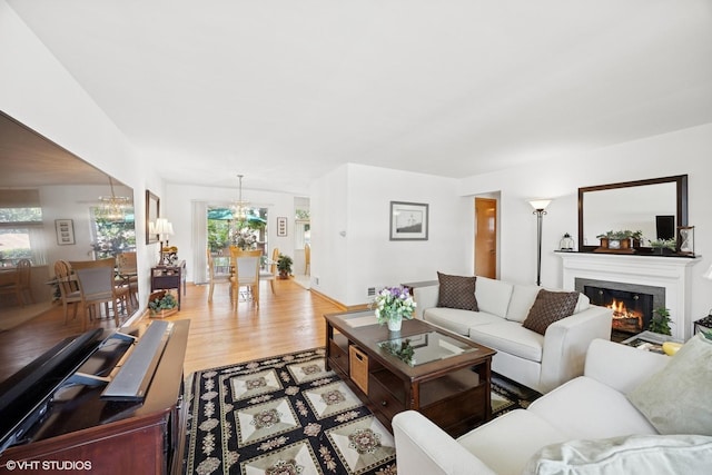 1865 Sunnyside Ave, Westchester, IL 60154 - living area featuring a glass covered fireplace, a chandelier, and light wood-style flooring