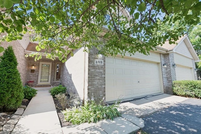 6919 Lexington Ct, Tinley Park, IL 60477 - view of front facade with brick siding, concrete driveway, an attached garage, and stucco siding