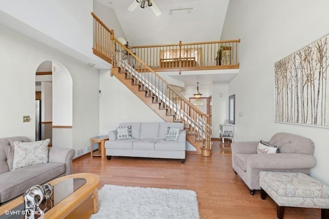 6919 Lexington Ct, Tinley Park, IL 60477 - living area featuring a high ceiling, a ceiling fan, wood finished floors, stairway, and arched walkways