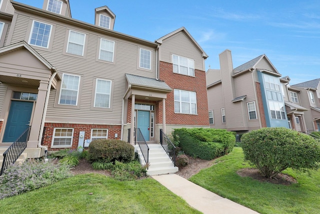 64 Village Station Ln, Grayslake, IL 60030 - townhome / multi-family property featuring brick siding and a front yard