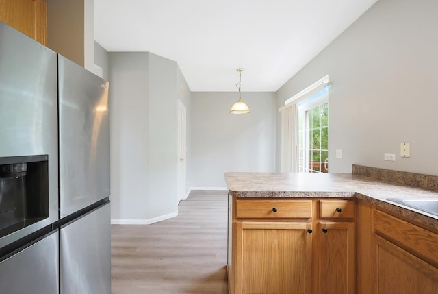 64 Village Station Ln, Grayslake, IL 60030 - kitchen featuring stainless steel fridge, light wood-type flooring, decorative light fixtures, a peninsula, and brown cabinets