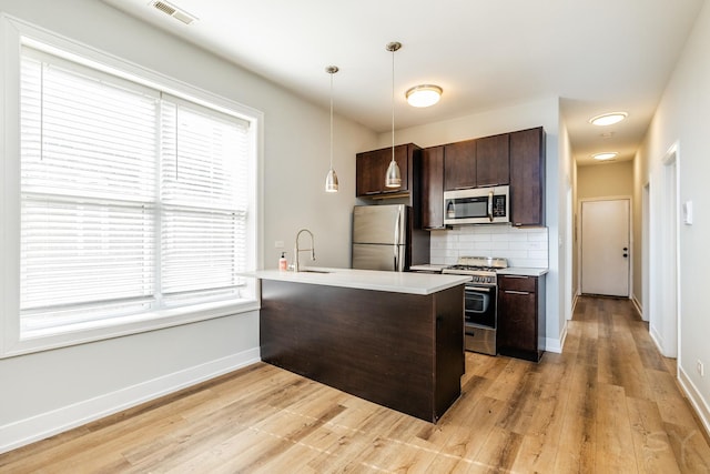 2244 S Sawyer Ave, Chicago, IL 60623 - kitchen with appliances with stainless steel finishes, dark brown cabinets, tasteful backsplash, and light countertops