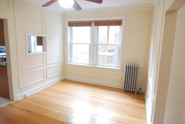 6207 N Winthrop Ave Unit 30, Chicago, IL 60660 - unfurnished room featuring radiator heating unit, a decorative wall, ceiling fan, light wood-type flooring, and crown molding