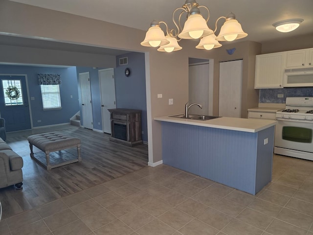 415 Andrea Ct, Harvard, IL 60033 - kitchen with white appliances, open floor plan, light countertops, light tile patterned floors, and white cabinets