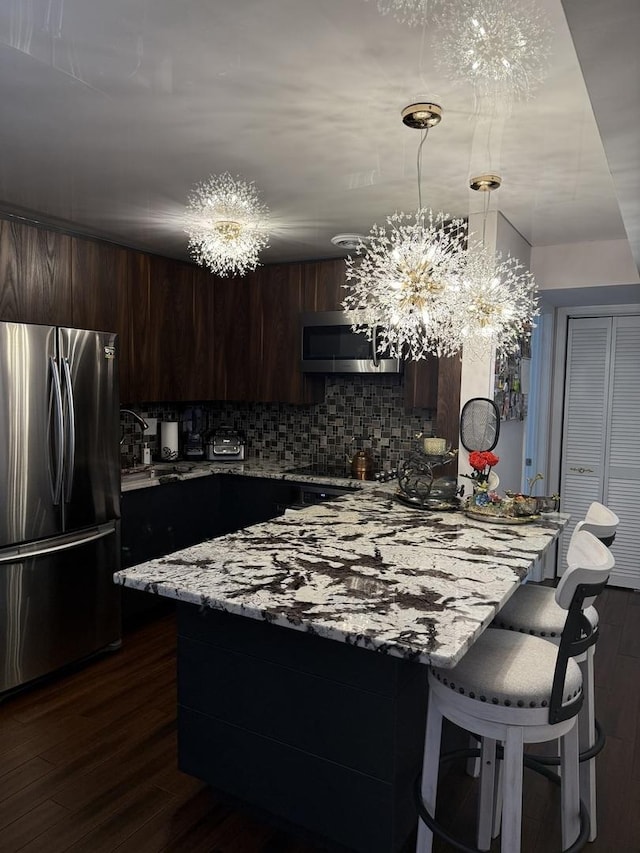 11A Kingery Quarter Unit 202, Willowbrook, IL 60527 - kitchen with appliances with stainless steel finishes, a peninsula, decorative backsplash, a kitchen breakfast bar, and a chandelier