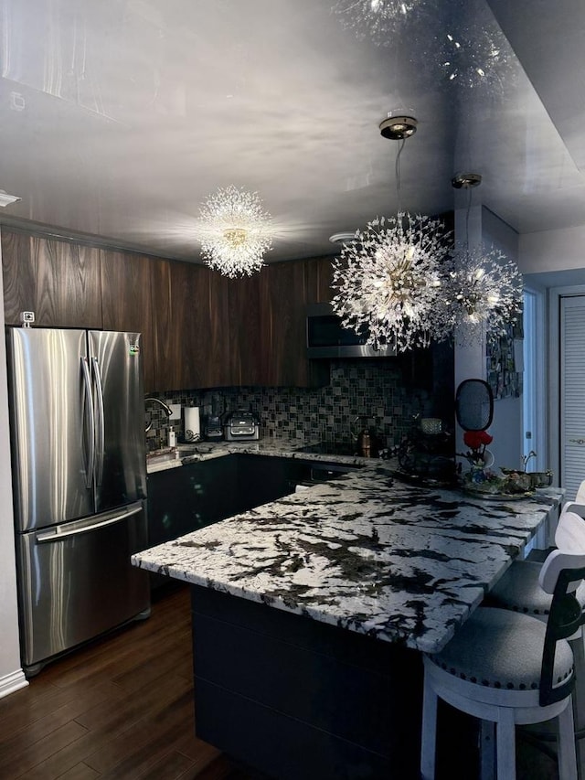 11A Kingery Quarter Unit 202, Willowbrook, IL 60527 - kitchen with freestanding refrigerator, dark brown cabinets, tasteful backsplash, a peninsula, and dark wood finished floors