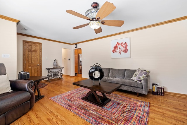 6759 W 91st St, Oak Lawn, IL 60453 - living room featuring crown molding, light wood-style floors, arched walkways, and a ceiling fan
