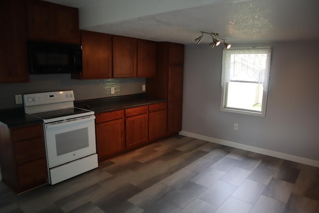 207 E N St, Walnut, IL 61376 - kitchen featuring white electric range, black microwave, dark countertops, a textured ceiling, and tasteful backsplash