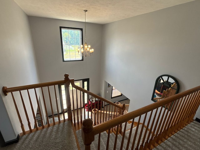 2952 Blue Oats Dr, Rockford, IL 61102 - staircase with carpet flooring, a chandelier, and a textured ceiling