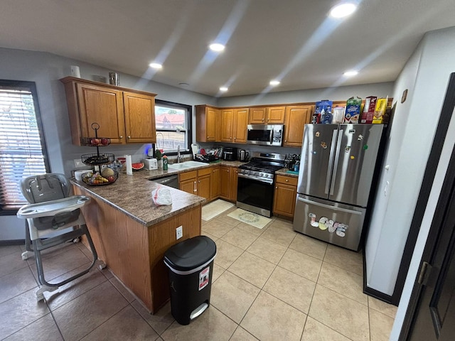 2952 Blue Oats Dr, Rockford, IL 61102 - kitchen featuring stainless steel appliances, a peninsula, brown cabinets, recessed lighting, and light tile patterned floors