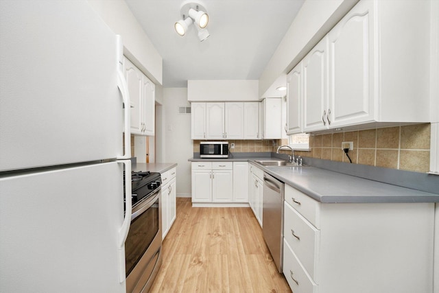 5145 Lee St, Skokie, IL 60077 - kitchen with stainless steel appliances, white cabinets, light wood-style flooring, and tasteful backsplash