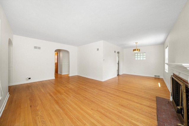 5145 Lee St, Skokie, IL 60077 - unfurnished living room with arched walkways, a fireplace, and light wood-type flooring