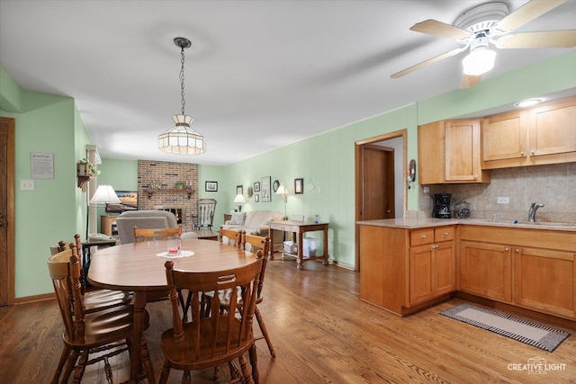 8349 Cristina Ave, Orland Park, IL 60462 - dining area with light wood-style floors, a brick fireplace, and ceiling fan