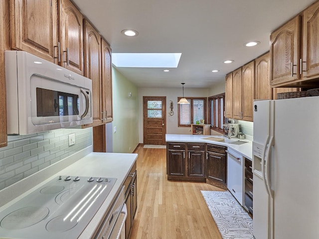 913 S See Gwun Ave, Mount Prospect, IL 60056 - kitchen featuring white appliances, a skylight, light wood-style floors, light countertops, and decorative backsplash