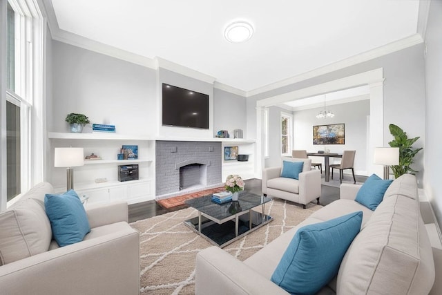 396 E Kensington Ave, Chicago, IL 60628 - living area featuring crown molding, a chandelier, wood finished floors, a brick fireplace, and ornate columns
